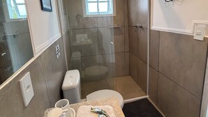 A bathroom with a shower, toilet, and sink.