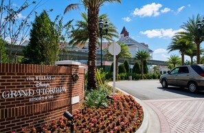 Segnaletica in mattoni per The Villas at Disney's Grand Floridian Resort & Spa, con una palma e un aiuola in primo piano.