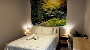 Ein Schlafzimmer mit einem Bett, Nachttischen, einem Schreibtisch und einem Stuhl.