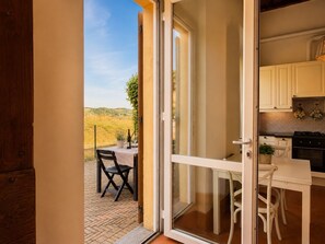 A room with a sliding glass door leading to an outdoor area with a table and chairs.