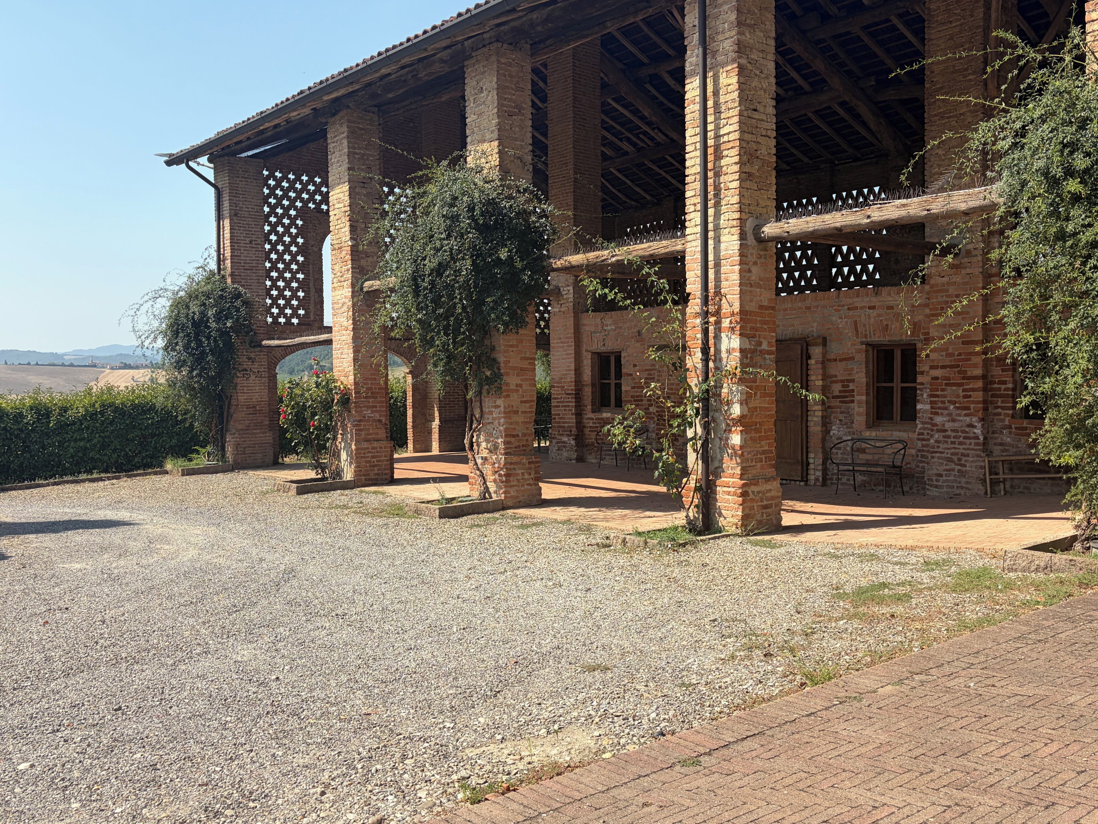 A building with a brick facade, large columns, and a covered patio area.