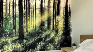 A bedroom with a large forest-themed wall mural, a wooden headboard, and a neatly made bed. - Elk - Private Bedroom near Downtown and 17th Av (Calgary)