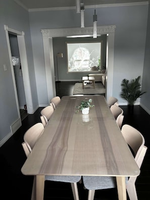 A conference room with a long table, chairs, a potted plant, and a window with a view. - Eagle - Private Bedroom near Downtown and 17th Av (Calgary)