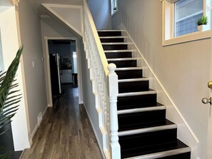 Eine Treppe mit weißen Balustraden und schwarzen Stufen, die zu einer Aussichtsplattform führt.