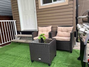 An outdoor seating area with wicker furniture and a grill. - Bear - Private Master Bedroom near DT and 17th Av (Calgary)