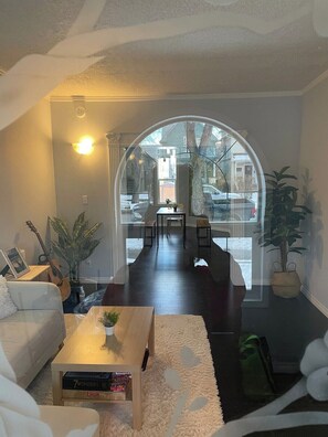 Ein Wohnzimmer mit einer Couch, einem Couchtisch und Blick durch ein großes Fenster.