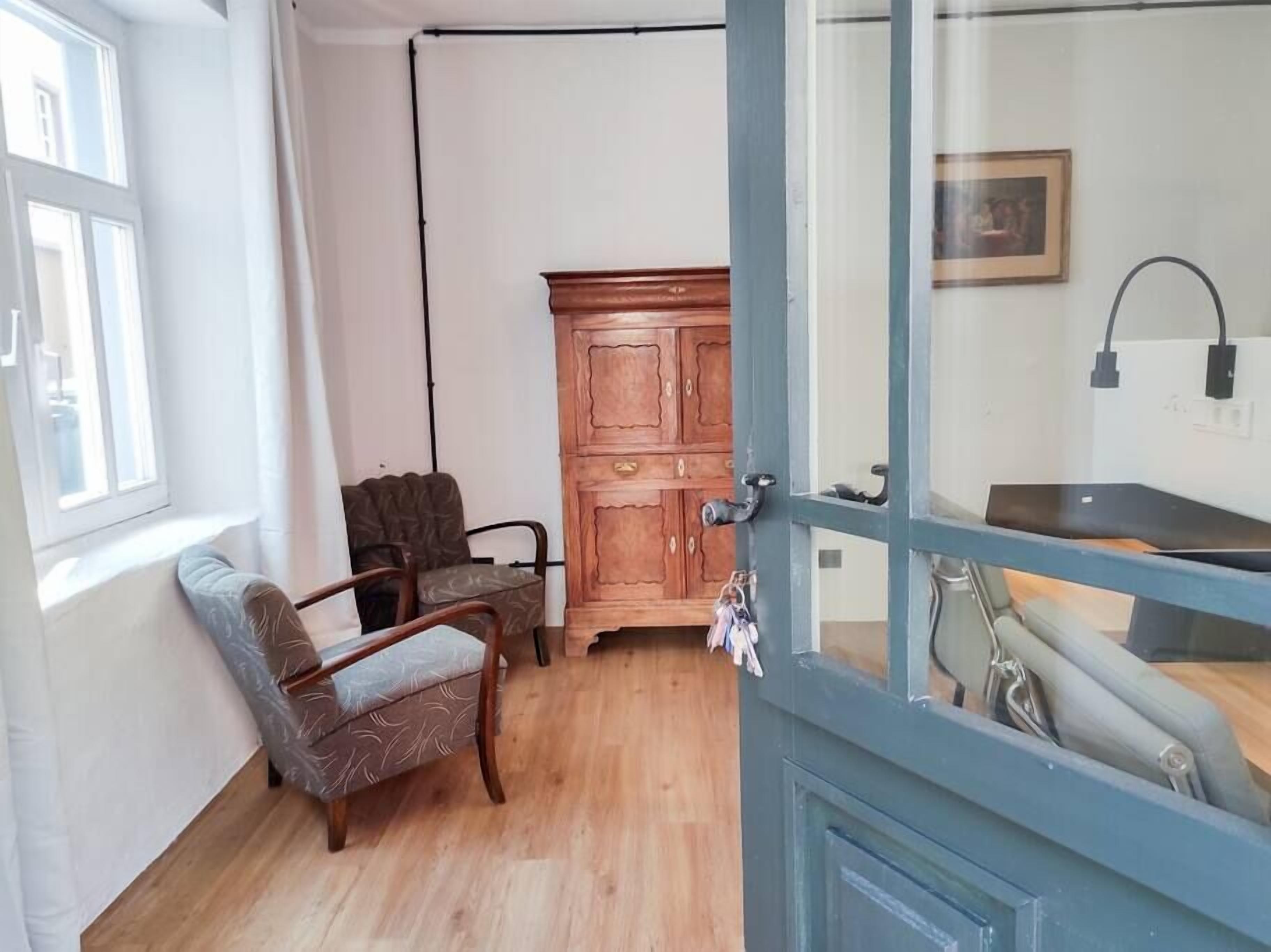 Une pièce comprenant un meuble en bois, une chaise et une table.