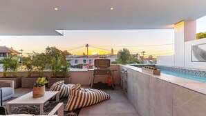 Terraço no telhado com piscina, área de estar e plantas em vasos.