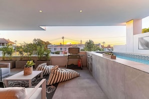 Eine Dachterrasse mit Pool, Sitzbereich und Topfpflanzen.