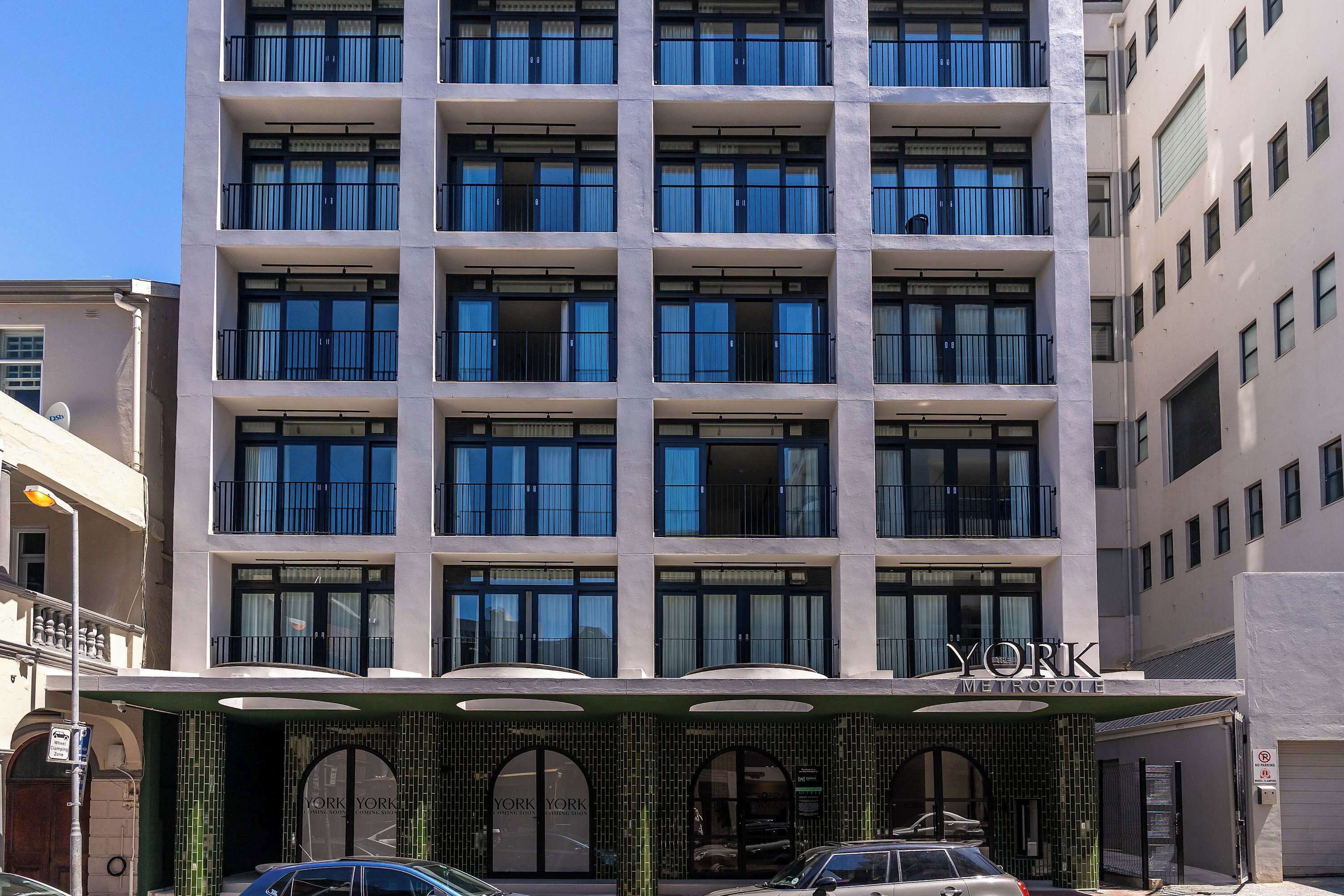 A multi-story hotel with a modern facade, large windows, and a prominent entrance with a sign reading "YORK METROPOLIS".