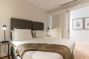A bedroom with a bed, bedside tables, a lamp, and a window with blinds. - In the heart of Cape Town, Pool - Skyline Apt 2112 (Cape Town)