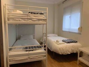 A bunk bed room with a window, a bedside table, and a bed with a blanket. - Málaga Apt Sleeps 5 · 10-min Walk to AVE Station (Málaga)