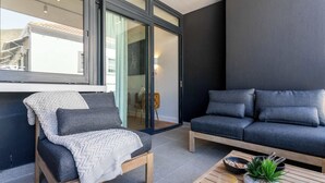 A modern living room with a sofa, a chair, and a coffee table. - Views, BBQ, Balcony, Sea Point - Jade Views Studio (Cape Town)