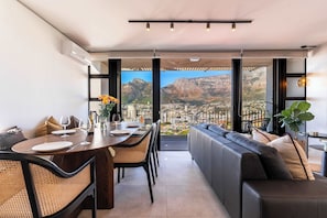 A modern dining area with a view of a city and mountains. - Stunning Views, Duplex, Bo-Kaap - Aerie Penthouse (Cape Town)