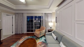 Un salón con sofá, sillón y una alfombra estampada.