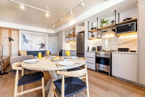 Eine moderne Küche mit einem runden Esstisch, integrierten Geräten und minimalistischem Design.