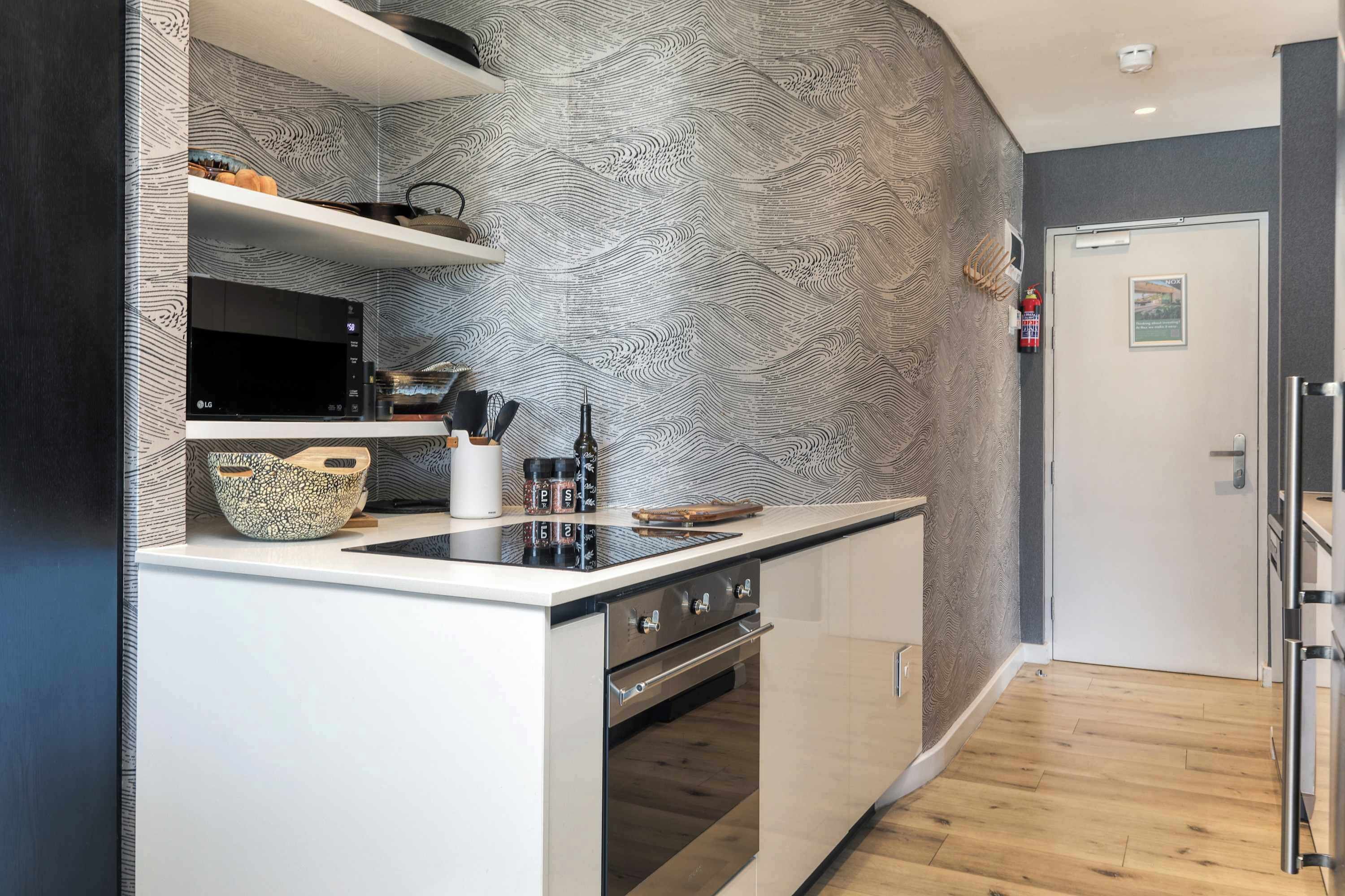 A modern kitchen with a microwave, stove, and various kitchen utensils.
