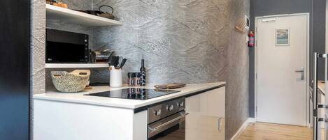 A modern kitchen with a microwave, stove, and various kitchen utensils.