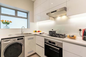 Eine moderne Küche mit eingebauter Waschmaschine, Backofen und Herd.