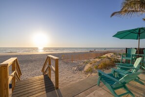 A wooden deck leading to a beach with a view of the ocean, green chairs, and an umbrella. - High-end Beach heaven, Sleeps 10, 3 private decks (Indian Rocks Beach)