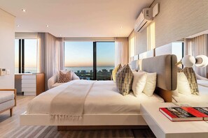 A modern hotel room with a large bed, a desk, and a view of the cityscape. - Sea Views, Luxurious, Pool -Iconic View Green Point (Cape Town)