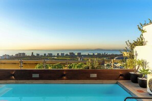 A rooftop pool with a city view, a 'No Diving' sign, and potted plants. - Sea Views, Luxurious, Pool -Iconic View Green Point (Cape Town)