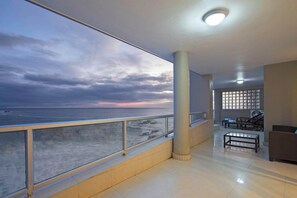 Ein großzügiger Balkon mit Meerblick, ein Fliesenboden und eine Sitzecke mit Tisch und Stühlen.