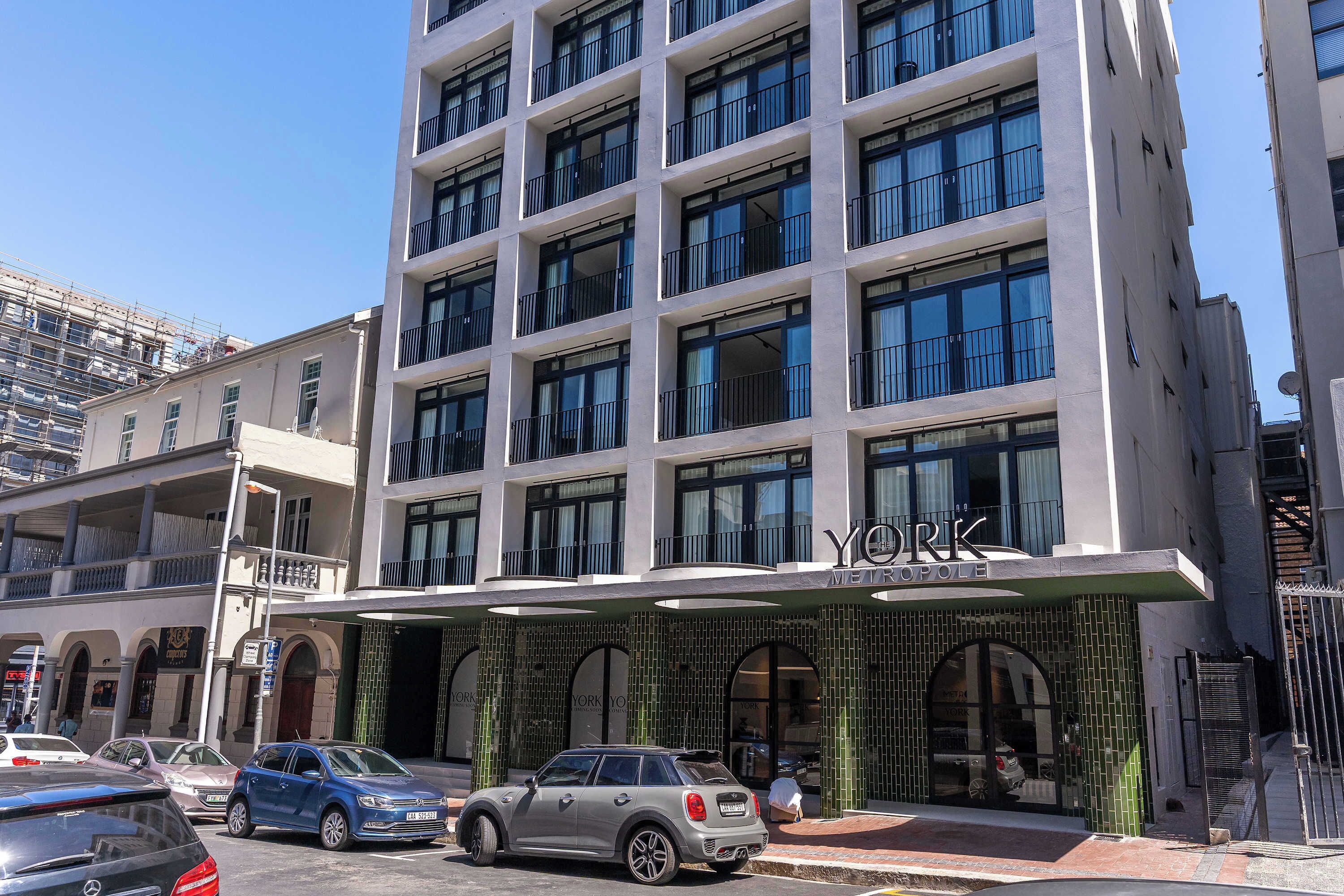 A modern building with a prominent "YORK METROPOLIS" sign, multiple balconies, and a gated entrance.