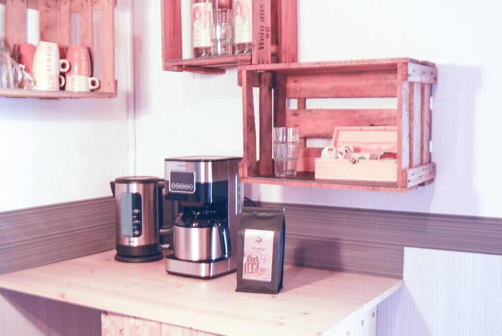 Una encimera de cocina con cafetera, hervidor y una bolsa de café.