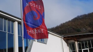 Et flag med teksten 'MOSEL THERME' på en bygning.