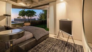 Ett modernt hotellrum med en stor säng, ett litet skrivbord och utsikt över stadsbilden.