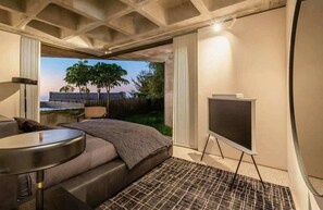 Ein modernes Hotelzimmer mit einem großen Bett, einem kleinen Schreibtisch und Blick auf eine Stadtlandschaft.