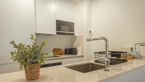 Eine moderne Küche mit Spüle aus Edelstahl, einer Mikrowelle und einem Blumentopf.