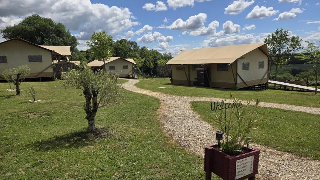 Ein Campingplatz mit mehreren Zelten und einem Kiesweg.