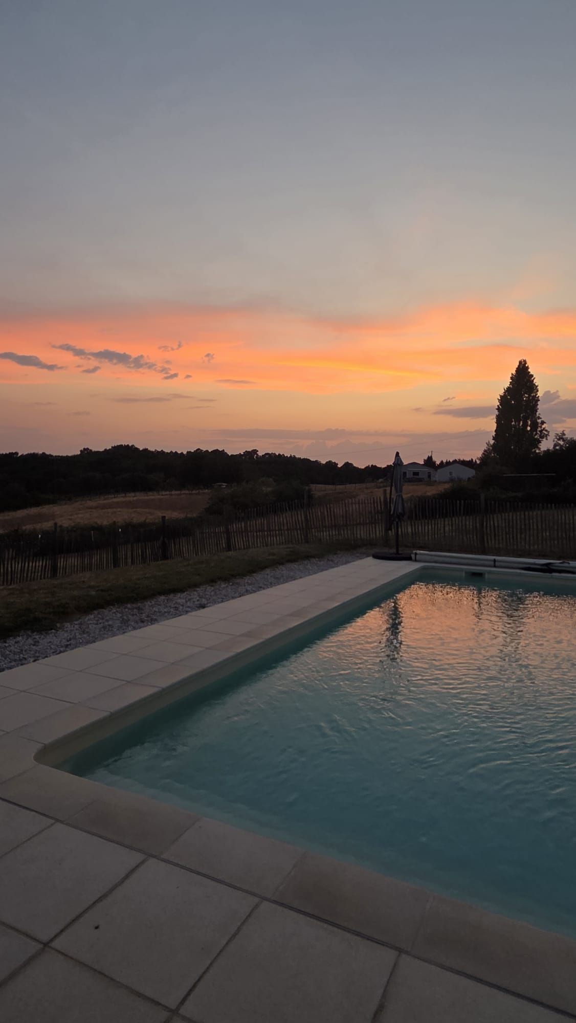 Une piscine avec vue sur le coucher de soleil.