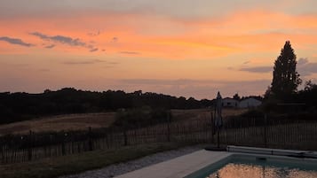 Une piscine avec vue sur le coucher de soleil.