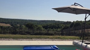 Una piscina con flotadores y una valla de madera al fondo.