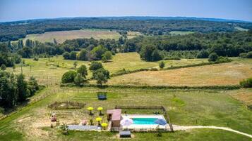 A rural property with a swimming pool, fenced garden, and a clear view of the surrounding countryside.