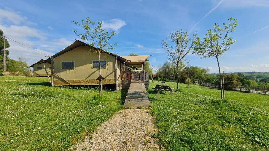 A single-story building with a covered porch, a gravel path leading to the entrance, and a picnic table nearby.