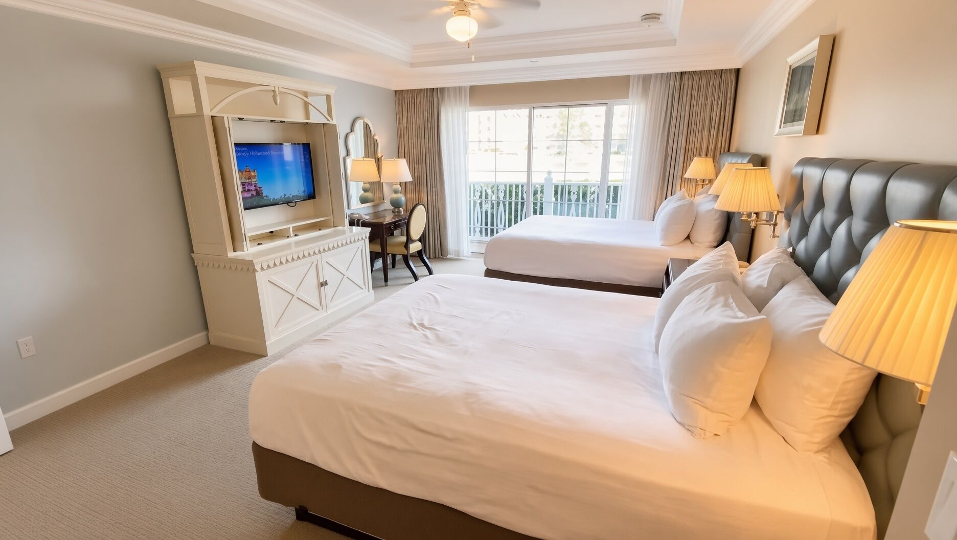 A hotel room with a large bed, a TV, a desk, and a balcony.