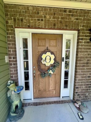 A wooden front door with a wreath, a small statue, and a mailbox. - 4 Bedroom Spacious Home Near Market (Thomasville)