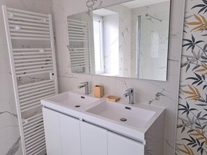 A bathroom with a white vanity, a large mirror, and a towel rack. - Holiday Home in Brittany With Sea View (Cleder)