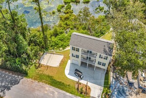 A two-story building with a flat roof, a covered parking area, and a small lawn. - Rosemary Villa, Heated Saltwater Pool, Volleyball Court, Golf Cart, Main ST (North Myrtle Beach)