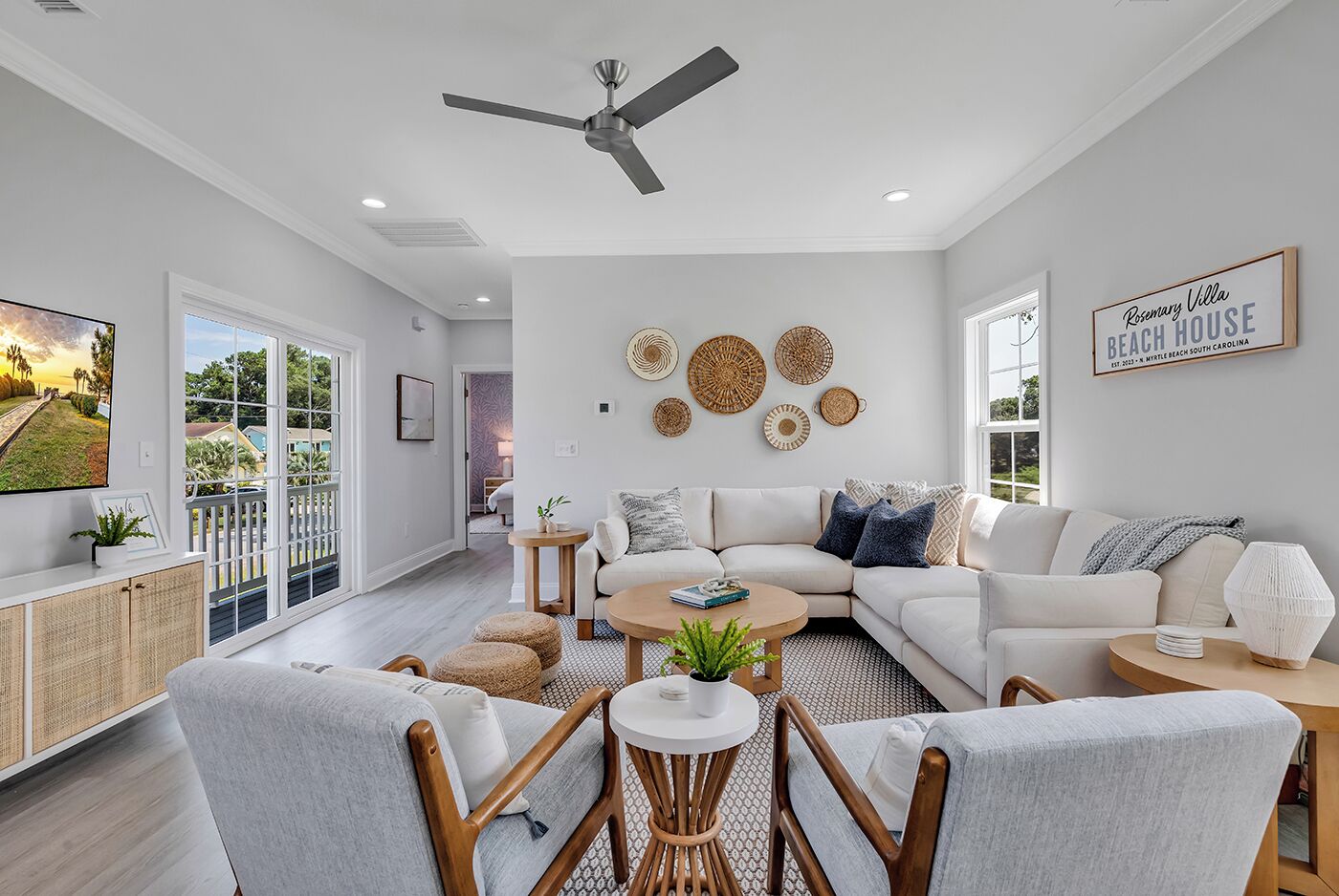 A spacious living room with a white sofa, a coffee table, and a ceiling fan.