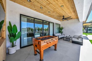 A modern outdoor area with a foosball table, seating, and a view of a swimming pool. - The signature Luxury Las Vegas Getaway (Las Vegas)