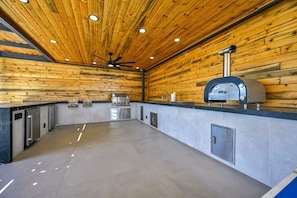 Eine moderne Küche mit Holzvertäfelung, Edelstahlgeräten und einem eingebauten Ofen.