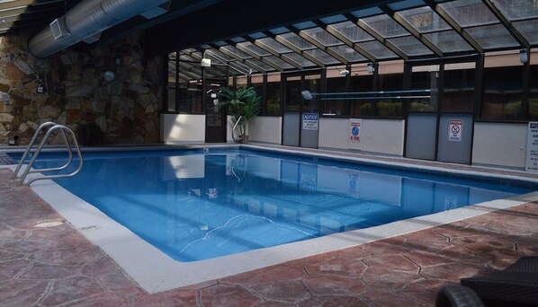 An indoor swimming pool with a stone wall, a metal ladder, and safety signs. - Christmas in Park City Ski Condo, slps 6, full kitchen, ski shuttle, Dec. 19-26 (Park City)