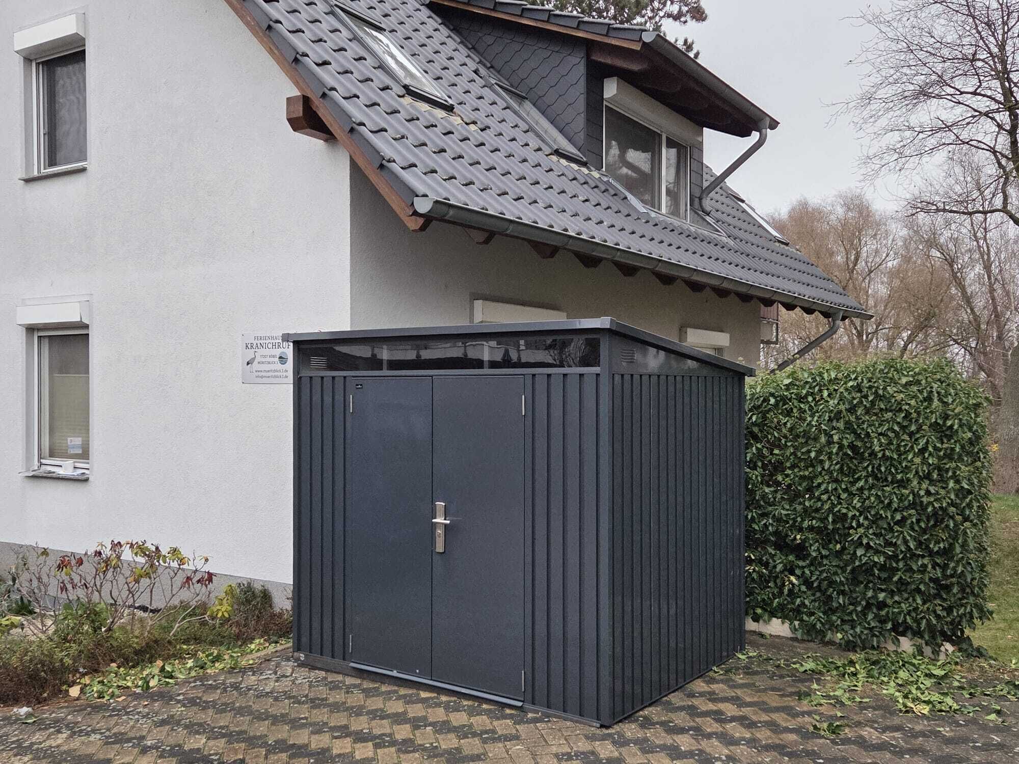 A building with a sloped roof, a dark-colored door, and a small window.