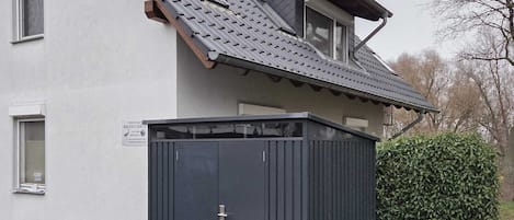 Un edificio con tetto spiovente, una porta scura e una piccola finestra.