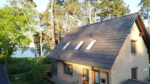 A two-story house with a sloped roof, skylights, and a brick exterior.